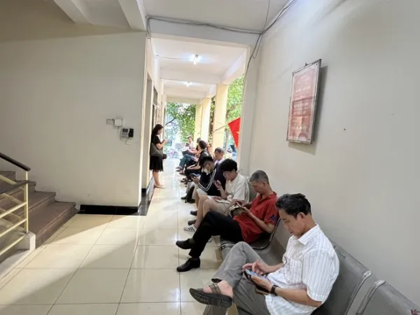 Người dân ngồi chờ đến lượt làm CCCD tại trụ sở Công an